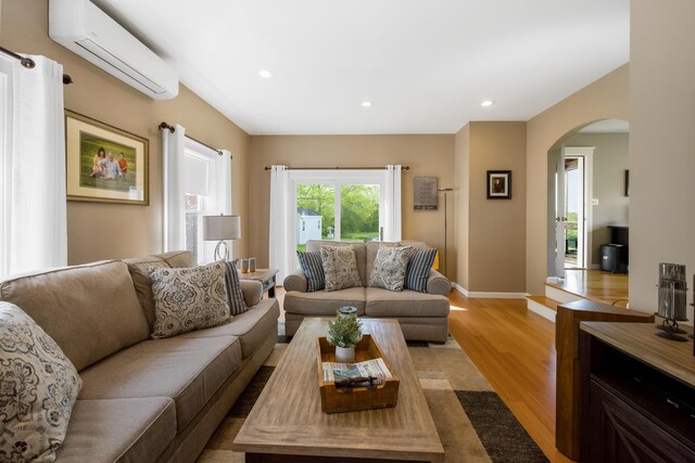 216 Monroe Rd, Winterport, ME 04496 - living room featuring a wall mounted AC, light wood finished floors, arched walkways, recessed lighting, and baseboards