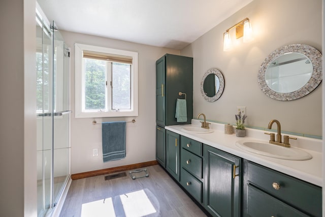 183 Buckfield Rd, Turner, ME 04282 - bathroom featuring wood finished floors, double vanity, baseboards, and a shower with door