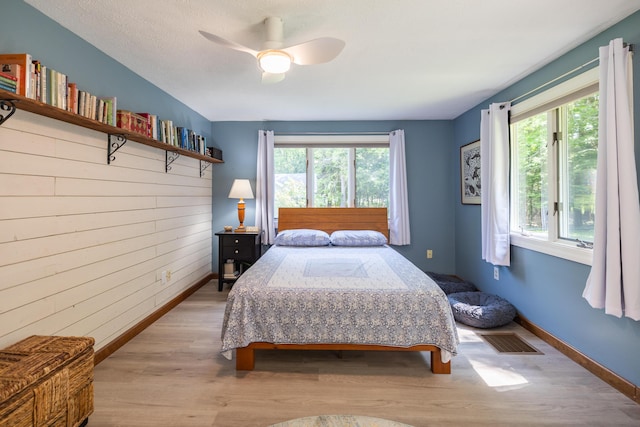 183 Buckfield Rd, Turner, ME 04282 - bedroom featuring wood walls, wood finished floors, baseboards, and a ceiling fan