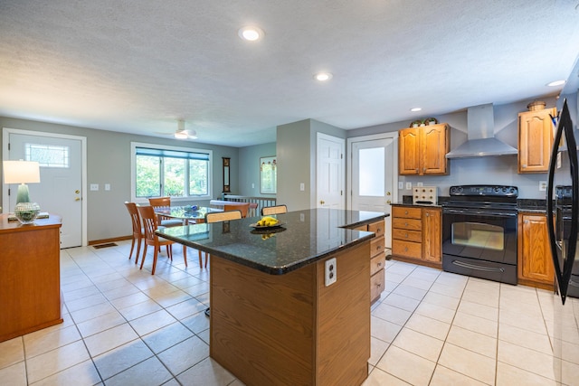 183 Buckfield Rd, Turner, ME 04282 - kitchen featuring wall chimney exhaust hood, black / electric stove, a kitchen island, light tile patterned floors, and recessed lighting
