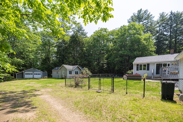 183 Buckfield Rd, Turner, ME 04282 - view of yard with a detached garage, driveway, an outdoor structure, view of wooded area, and a gate
