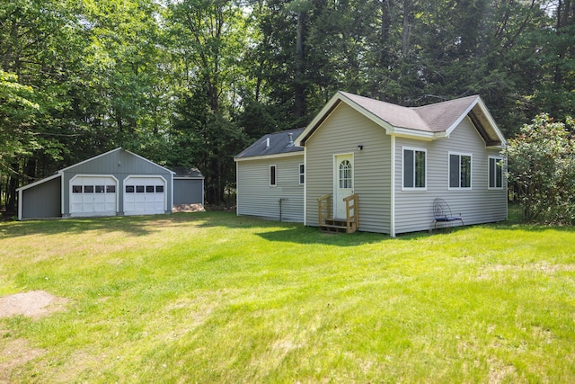 183 Buckfield Rd, Turner, ME 04282 - view of property exterior featuring a garage, an outbuilding, a yard, and roof with shingles