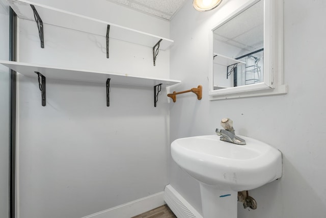 32 Long Hall Dr, Berwick, ME 03901 - bathroom featuring a baseboard heating unit and wood finished floors