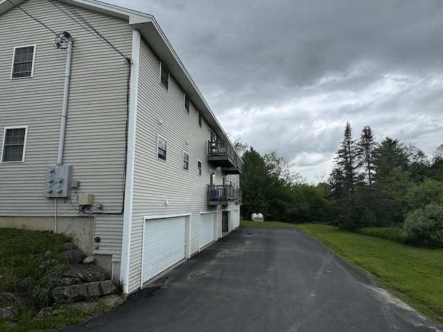 541 Kenduskeag Ave Unit A1, Bangor, ME 04401 - view of side of home featuring a balcony, asphalt driveway, and a garage
