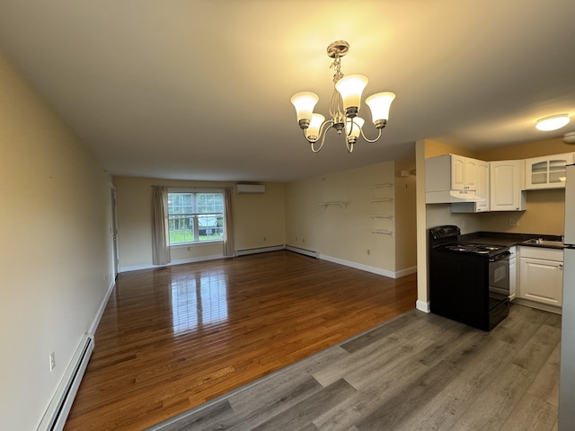 541 Kenduskeag Ave Unit A1, Bangor, ME 04401 - kitchen featuring black range, open floor plan, baseboard heating, an AC wall unit, and a baseboard radiator