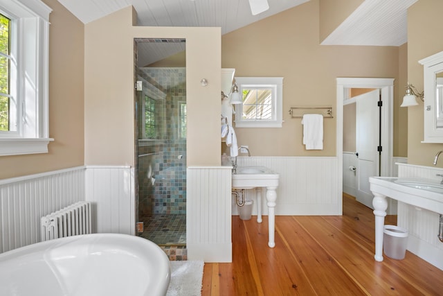 4 Shore Rd, Biddeford, ME 04005 - bathroom featuring lofted ceiling, radiator, hardwood / wood-style flooring, a stall shower, and a wainscoted wall