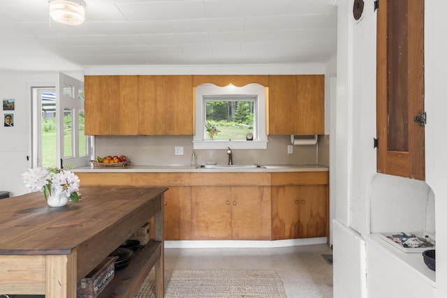37 Walker Rd, Boothbay, ME 04537 - kitchen with brown cabinets, light countertops, dark aggregate flooring, and tasteful backsplash