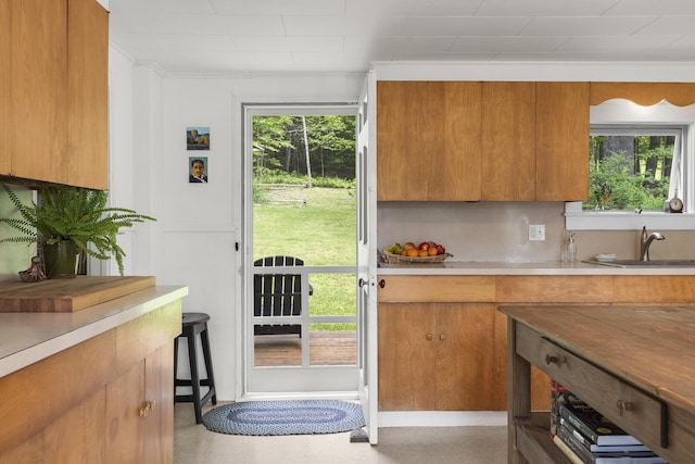 37 Walker Rd, Boothbay, ME 04537 - kitchen with brown cabinetry, light countertops, ornamental molding, and decorative backsplash