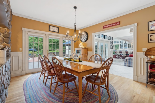 30 Plymouth Dr, Saco, ME 04072 - dining space with a wainscoted wall, a decorative wall, french doors, a chandelier, and light wood-style floors
