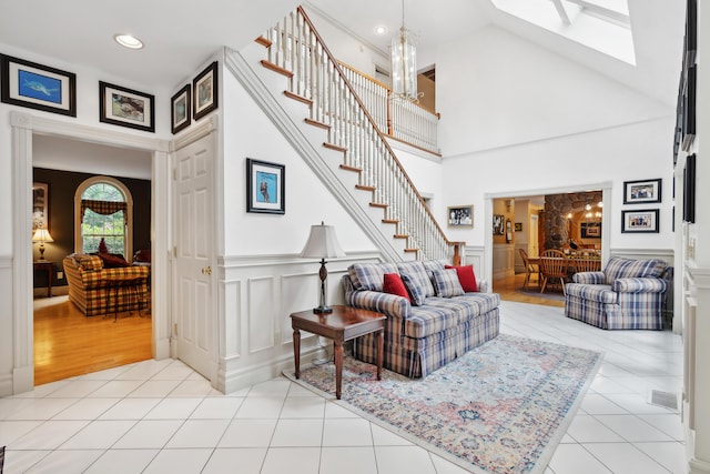 30 Plymouth Dr, Saco, ME 04072 - living area featuring stairway, a chandelier, tile patterned floors, a skylight, and a decorative wall