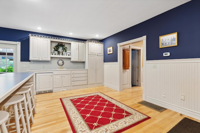 30 Plymouth Dr, Saco, ME 04072 - kitchen with light wood finished floors, wainscoting, white cabinets, light countertops, and open shelves