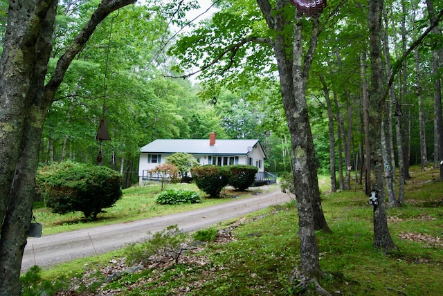 16 Evergreen Estates Rd, Nobleboro, ME 04555 - ranch-style house featuring a chimney, a forest view, a metal roof, and dirt driveway