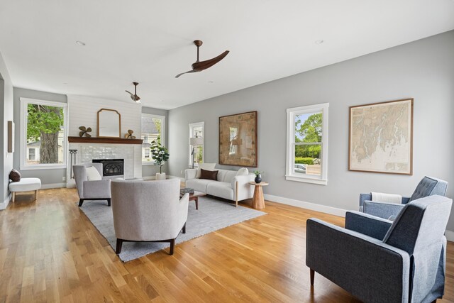 217 Ocean Ave, Portland, ME 04103 - living area featuring light wood-style floors, a large fireplace, baseboards, and ceiling fan