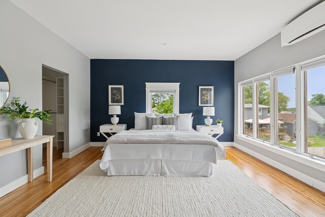 217 Ocean Ave, Portland, ME 04103 - bedroom featuring a wall mounted AC, light wood finished floors, an accent wall, and baseboards