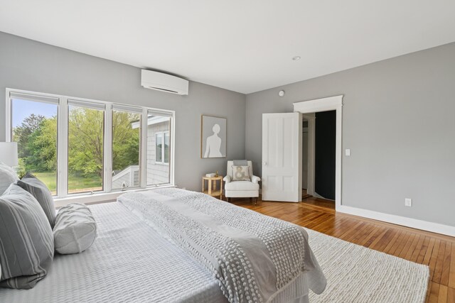 217 Ocean Ave, Portland, ME 04103 - bedroom with a wall mounted air conditioner, hardwood / wood-style floors, and baseboards