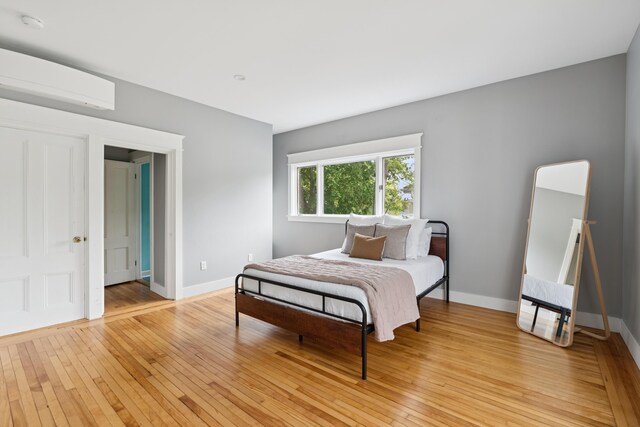 217 Ocean Ave, Portland, ME 04103 - bedroom with light wood-style flooring, baseboards, and a wall unit AC