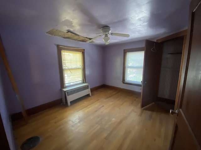 147 Spring St, Westbrook, ME 04092 - unfurnished bedroom featuring radiator, multiple windows, light wood-type flooring, and baseboards