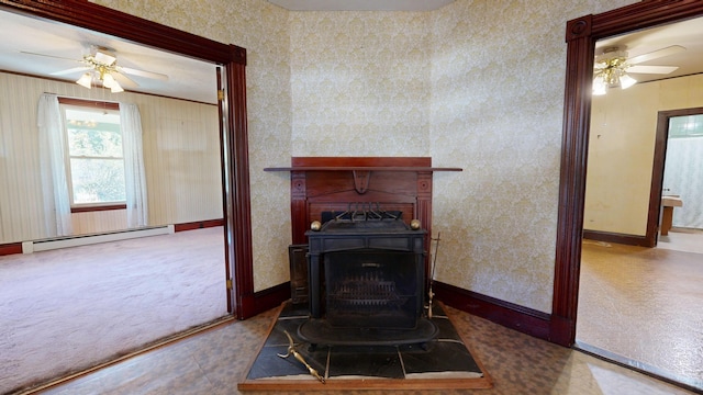 143 Union Ave, Old Orchard Beach, ME 04064 - living area featuring a wood stove, a baseboard heating unit, ceiling fan, baseboards, and carpet floors