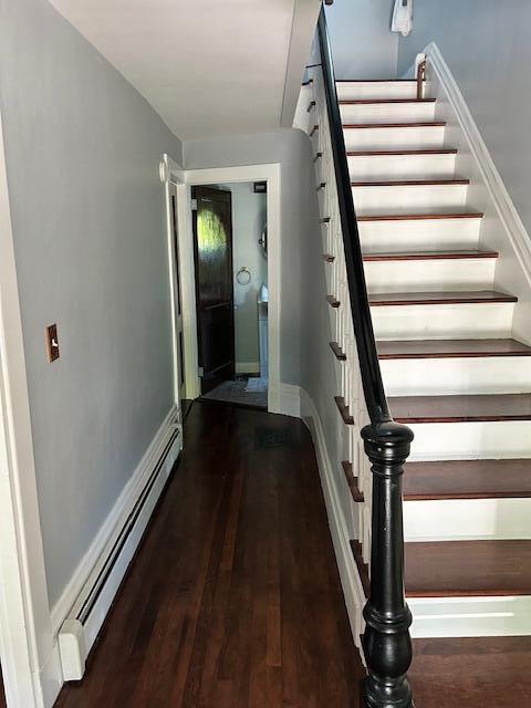 48 Allen St, Bangor, ME 04401 - stairway featuring baseboard heating, wood finished floors, and baseboards
