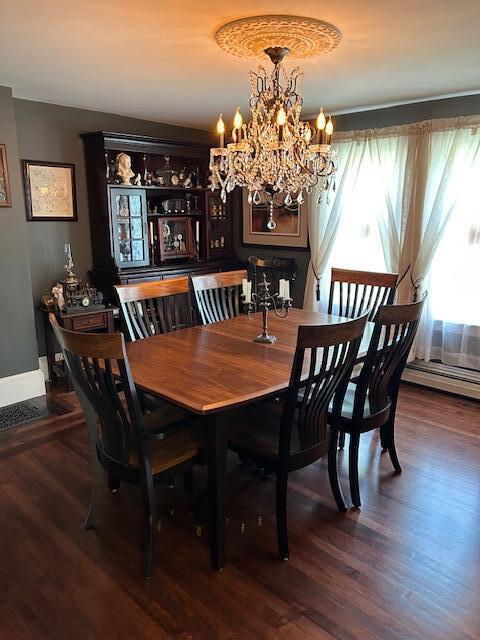 48 Allen St, Bangor, ME 04401 - dining space with a chandelier, baseboard heating, wood finished floors, and baseboards