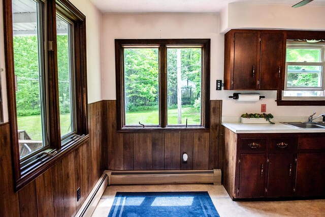130 Davis Rd, Fairfield, ME 04937 - kitchen with a sink, baseboard heating, a wainscoted wall, light countertops, and wood walls