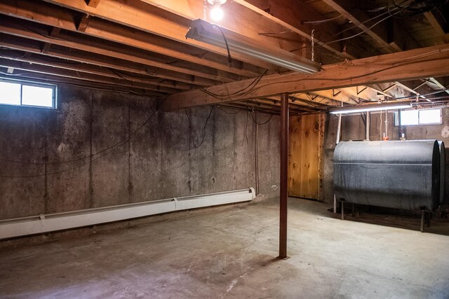 130 Davis Rd, Fairfield, ME 04937 - below grade area with oil tank, a baseboard heating unit, and plenty of natural light
