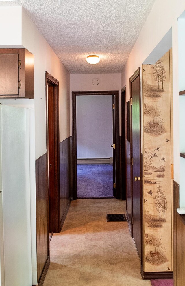 130 Davis Rd, Fairfield, ME 04937 - corridor with a textured ceiling and a baseboard heating unit