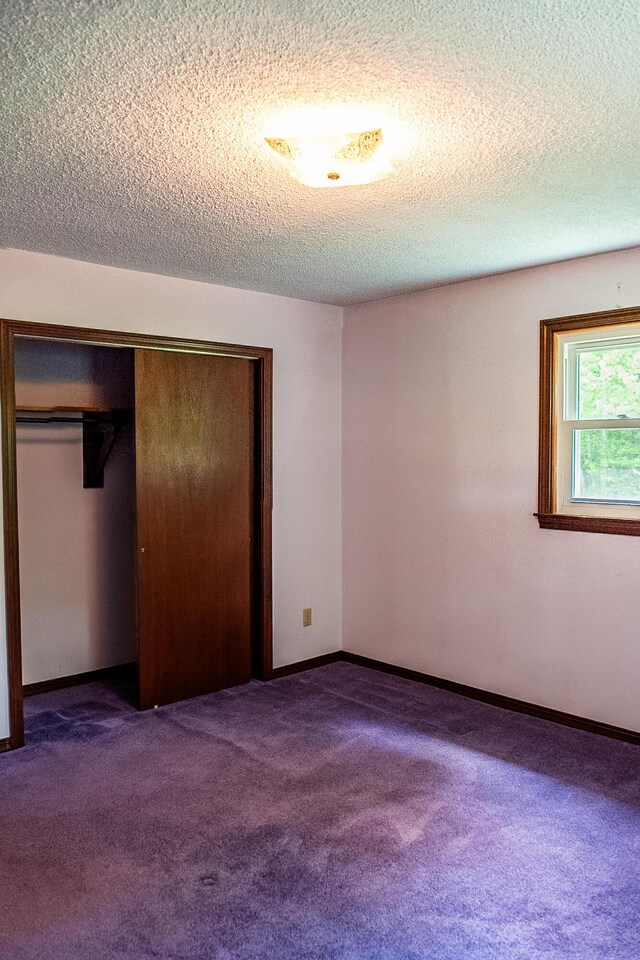 130 Davis Rd, Fairfield, ME 04937 - unfurnished bedroom featuring carpet flooring, a textured ceiling, a closet, and baseboards