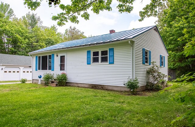 130 Davis Rd, Fairfield, ME 04937 - view of front of home with a standing seam roof, a chimney, metal roof, a garage, and a front yard