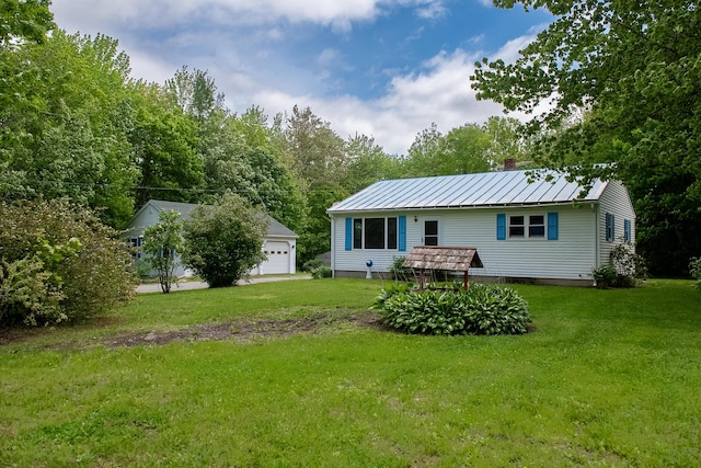 130 Davis Rd, Fairfield, ME 04937 - back of house featuring a yard, a chimney, a detached garage, metal roof, and an outbuilding