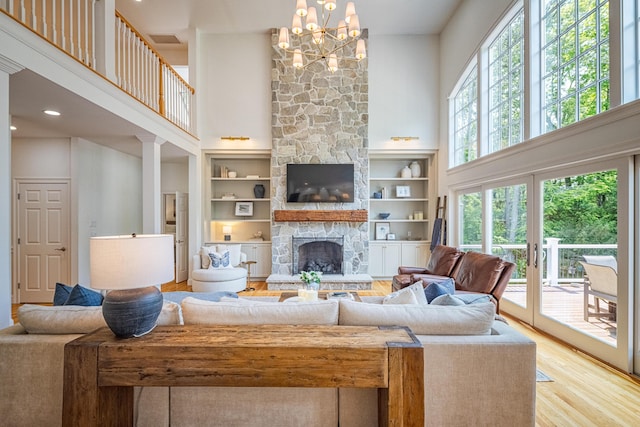 20 Doe Dr, Eliot, ME 03903 - living area featuring a towering ceiling, a stone fireplace, wood finished floors, and a chandelier