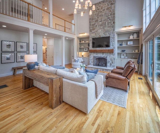 20 Doe Dr, Eliot, ME 03903 - living area featuring a towering ceiling, wood finished floors, a fireplace, a chandelier, and baseboards