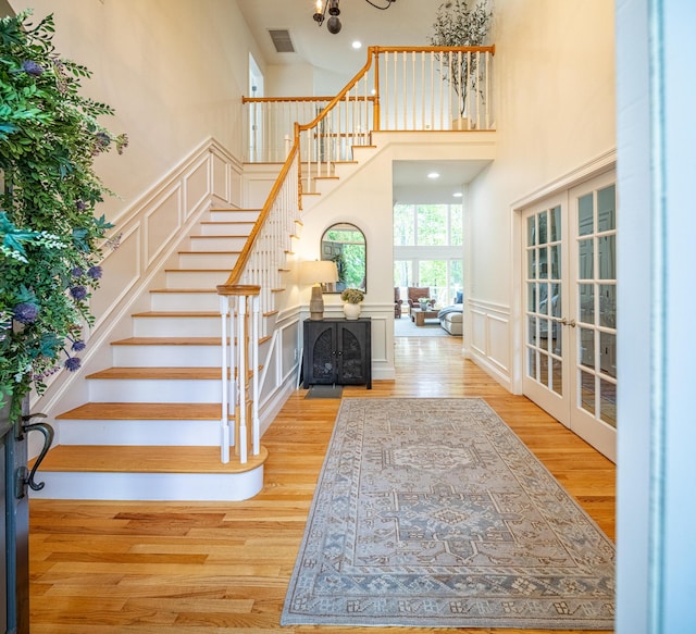 20 Doe Dr, Eliot, ME 03903 - entryway with wood finished floors, stairs, a towering ceiling, french doors, and a decorative wall