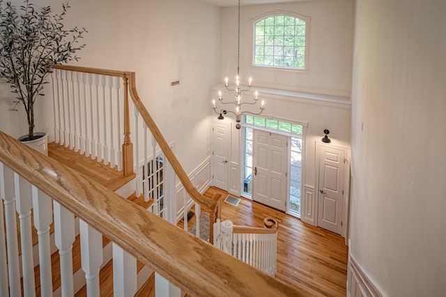 20 Doe Dr, Eliot, ME 03903 - foyer entrance featuring wood finished floors, a chandelier, stairs, and a towering ceiling