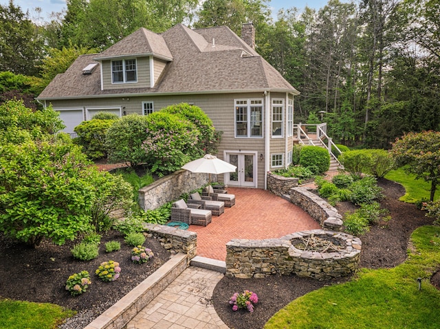 20 Doe Dr, Eliot, ME 03903 - view of front of property featuring french doors, a shingled roof, a chimney, a patio area, and an outdoor living space with a fire pit