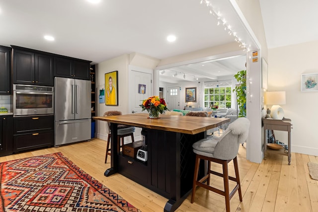 83 Brixham Rd, York, ME 03909 - kitchen featuring appliances with stainless steel finishes, butcher block countertops, a breakfast bar area, light wood-type flooring, and recessed lighting