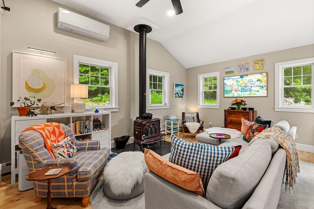 83 Brixham Rd, York, ME 03909 - living room with a wood stove, a wall mounted AC, wood finished floors, vaulted ceiling, and plenty of natural light