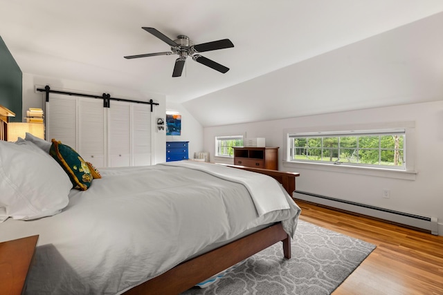 83 Brixham Rd, York, ME 03909 - bedroom with baseboard heating, wood finished floors, a barn door, vaulted ceiling, and ceiling fan