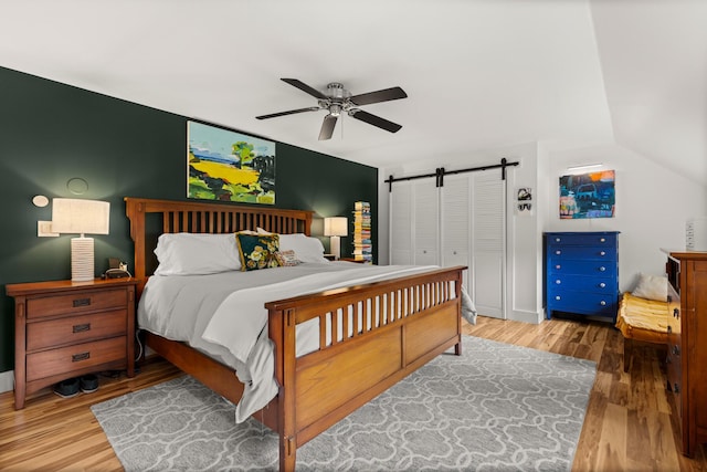 83 Brixham Rd, York, ME 03909 - bedroom featuring a barn door, wood finished floors, a ceiling fan, and vaulted ceiling