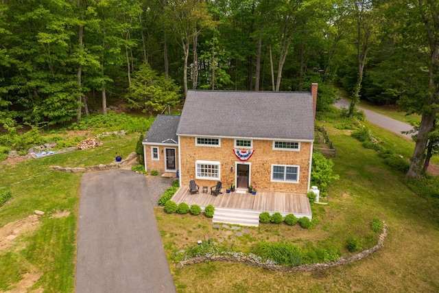 83 Brixham Rd, York, ME 03909 - shingle-style home featuring a chimney, a deck, a forest view, a front yard, and roof with shingles