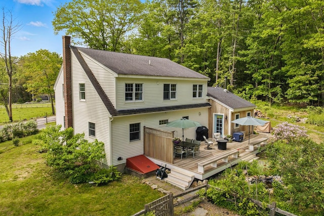 83 Brixham Rd, York, ME 03909 - back of house featuring a deck, a chimney, roof with shingles, outdoor dining area, and a lawn