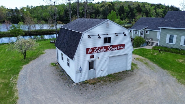 590 Main St, East Machias, ME 04630 - view of front of home with driveway, roof with shingles, a gambrel roof, a water view, and a wooded view