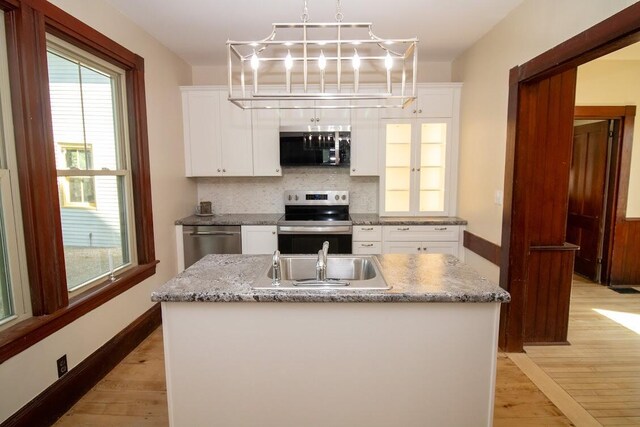12 Park Ave, Newport, ME 04953 - kitchen with stainless steel appliances, a sink, tasteful backsplash, white cabinets, and light wood-type flooring