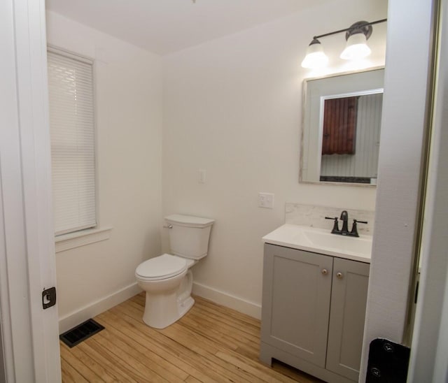 12 Park Ave, Newport, ME 04953 - bathroom featuring toilet, vanity, wood finished floors, and baseboards