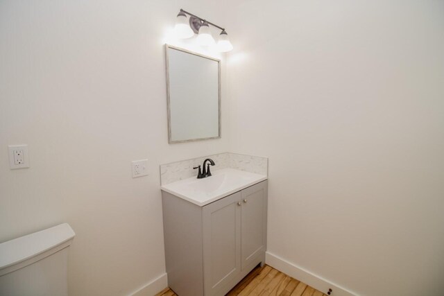 12 Park Ave, Newport, ME 04953 - half bath featuring baseboards, vanity, toilet, and wood finished floors