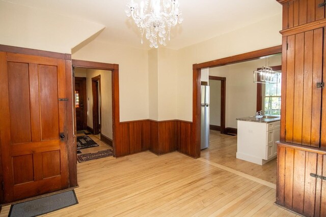 12 Park Ave, Newport, ME 04953 - spare room with a chandelier, light wood-style floors, wainscoting, and wooden walls