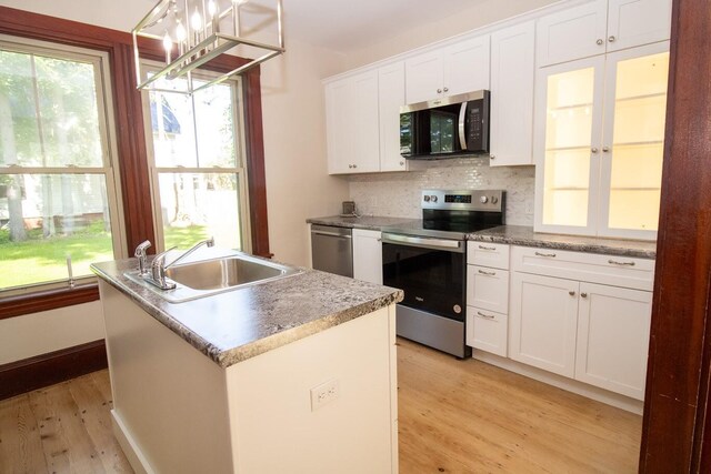 12 Park Ave, Newport, ME 04953 - kitchen featuring stainless steel appliances, a sink, light wood-style flooring, decorative backsplash, and white cabinets