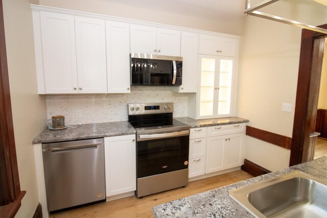 12 Park Ave, Newport, ME 04953 - kitchen featuring appliances with stainless steel finishes, white cabinets, tasteful backsplash, light wood-style flooring, and stone counters