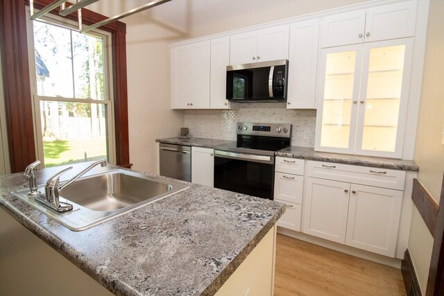 12 Park Ave, Newport, ME 04953 - kitchen with stainless steel appliances, a sink, white cabinets, tasteful backsplash, and light wood-style floors