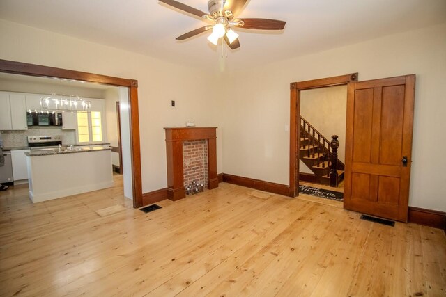 12 Park Ave, Newport, ME 04953 - unfurnished room with light wood-style floors, ceiling fan, stairway, and baseboards